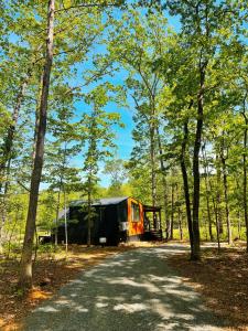 a truck parked in the woods next to a road at Bison Farm - Cabin Brisa in Culpeper