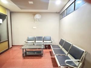 a waiting room with chairs and a table and a fan at Century Regency in Cochin
