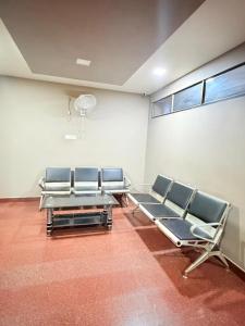 a room with chairs and a wall with a window at Century Regency in Cochin