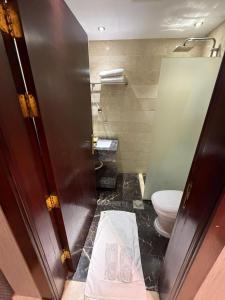 a bathroom with a toilet next to a door at فندق تمكين-TamkeenHotel- تابع لعلامة كلاديوم- A Cladium brand in Medina