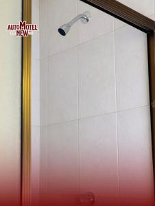 a shower with a shower head on a wall at New Auto Motel in Barcelona
