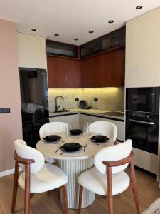 a kitchen with a table with four chairs and a kitchen with a counter at FIN Skyline Apartment in Krujë
