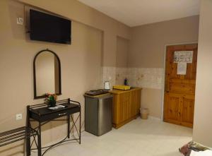 a bathroom with a sink and a television on the wall at Alexia Ferentinou in Fiskardo +99 photos