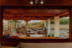 a view of a porch with chairs and a hammock at Echoes Surf Casitas in Mechapa