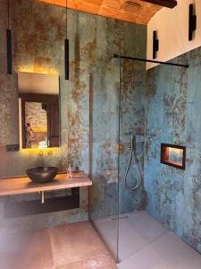 a bathroom with a glass shower and a sink at Masia de Can Roig in Riells +78 photos