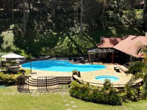 a large swimming pool in a yard next to a house at Casa 05 Vale Boa Vista - Refúgio Moderno em Condomínio Exclusivo in Teresópolis