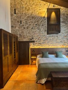 a bedroom with two beds and a stone wall at Masia de Can Roig in Riells
