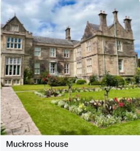 a large house with a garden in front of it at the ring of kerry riverside apartment in Killorglin