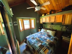 a bedroom with a bed and a ceiling fan at Bison Farm - Cabin "Vieja" in Culpeper
