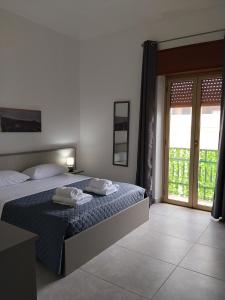a bedroom with a bed with two towels on it at Carolina's Bedrooms in Trapani