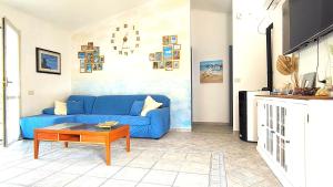 a blue couch in a living room with a table at Domus de mare in Cala Gonone