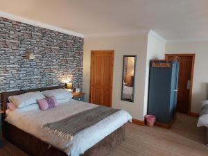a bedroom with a bed and a brick wall at Bellevue Inn in Saint Margarets Hope