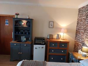 a room with a kitchen with a cabinet and a refrigerator at Bellevue Inn in Saint Margarets Hope