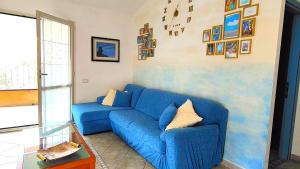 a blue couch in a living room with pictures on the wall at Domus de mare in Cala Gonone