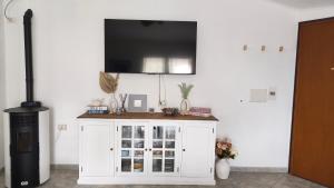 a white cabinet with a television on a wall at Domus de mare in Cala Gonone