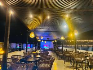 a restaurant with tables and chairs and lights at Hotel Palmeras Los Cabos in Cabo San Lucas