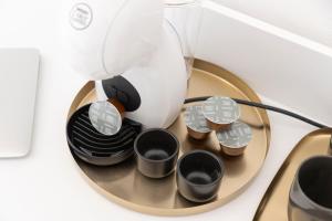 a coffee maker with four cups on a plate at Sant'Elena Rooms in Quartu SantʼElena