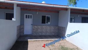 a small house with a sign in front of it at Complejo las Quintas in Santa Teresita