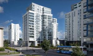 a bus is parked in front of a tall building at Appartment in Espoo in Helsinki