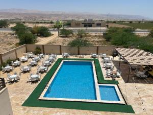 a swimming pool with tables and chairs on a resort at Green view in Al Mazār