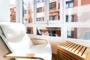a white chair sitting in front of a window at Infinium Zamora Suites con parking in Zamora
