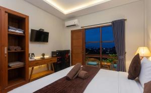 a bedroom with a large bed and a window at Naksa Homestay Sanur in Sanur