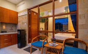a small kitchen with a table and chairs and a bedroom at Naksa Homestay Sanur in Sanur
