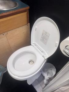 eine weiße Toilette mit einem Aufkleber auf dem Deckel in der Unterkunft Comfy camper in Tampa + 1 Foto