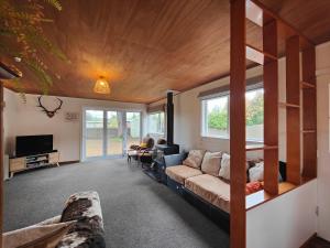 a living room with a couch and a tv at Arrive and Revive Te Anau in Te Anau