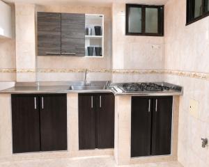 a kitchen with black cabinets and a sink at El Velero Apartamentos By DANP in Santa Marta +184 photos