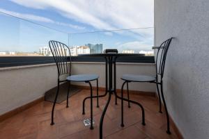 two chairs and a table in front of a window at Habitat Suites III in Craiova