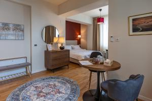 a hotel room with a bed and a table at Habitat Suites III in Craiova