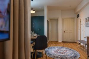 a living room with a table and a chair at Habitat Suites III in Craiova