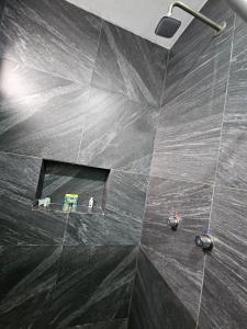 a bathroom with a large black tiled wall at Hostal Livette in Guadalajara