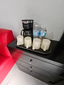 a tray with a coffee maker and water bottles at Hostal Livette in Guadalajara