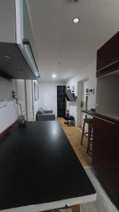 a kitchen and living room with a black counter top at 1A chambre confortable 02 in Audun-le-Tiche