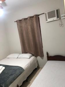 ein Schlafzimmer mit Bett und Fenster mit Klimaanlage in der Unterkunft Hotel Eldorado in Eldorado
