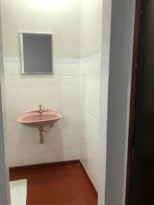 ein Badezimmer mit einem rosa Waschbecken und einem Spiegel in der Unterkunft Hotel Eldorado in Eldorado