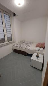 a small bedroom with a bed and a window at 1A chambre confortable 02 in Audun-le-Tiche