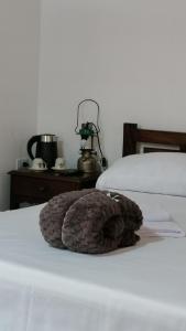 a stuffed animal is sitting on a bed at Los Arrieros - Hospedaje Rural in Manizales