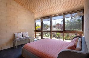 a bedroom with a bed and a large window at Retro Reservoir Retreat in Kennington