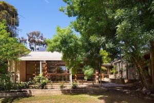 a house with glass windows and trees at Retro Reservoir Retreat in Kennington