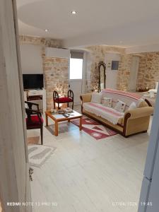 a living room with a couch and a table at Suites-Xenonas "Alexandra's Coffee House" in Volímai