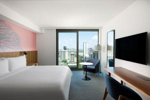 a hotel room with a bed and a desk and a television at Renaissance Honolulu Hotel & Spa in Honolulu