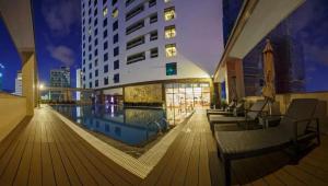 a building with a swimming pool in a city at night at Sunrise Sea View Apartment in Nha Trang