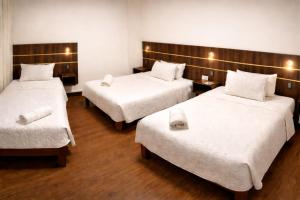 a room with three beds with white sheets at El Solar Inn in Arequipa +34 photos