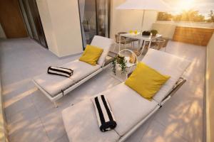 a living room with two white chairs and a table at Dream House Las Terrenas Terraza privada & Jacuzzi in Las Terrenas