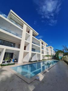 a large white building with a swimming pool at Dream House Las Terrenas Terraza privada & Jacuzzi in Las Terrenas