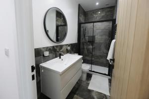 a bathroom with a white sink and a mirror at Spacious 6-Guest Retreat with Pool Table in Dinnington +11 photos