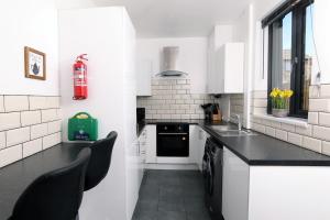 a kitchen with white walls and black counter tops at Spacious 6-Guest Retreat with Pool Table in Dinnington